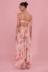 Falda larga color rosado con estampado floral, tiro alto y diseño fluido con gran movimiento.