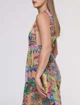 Vestido largo sin mangas de gasa color rosa, con estampado tipo patchwork tropical que incluye piñas, flamencos y motivos botánicos. Cuenta con un pronunciado escote en V y cintura elastizada.