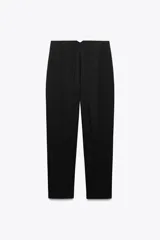 Pantalón blanco de vestir, de tiro alto y corte recto. Presenta bolsillos delanteros de vivo y cierre frontal con cremallera, botón interior y gancho metálico.