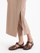 Pollera midi negra de canalé con cintura elástica y tajo lateral en el dobladillo.