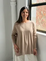 Sweater de punto color visón con cuello redondo, mangas largas con puños acanalados y diseño holgado con detalle de costura vertical central.