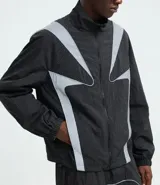 Campera liviana de poliamida con diseño cuadrillé sutil, cuello alto y cierre frontal. Presenta paneles reflectivos estratégicos para mayor visibilidad, puños elásticos y corte contemporáneo.