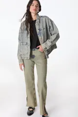 Campera de denim celeste con efecto lavado, corte recto, cuello camisero, cierre frontal con botones metálicos, bolsillos de parche en el pecho y laterales.