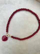 Collar de cuentas esféricas de vidrio pulido en color rojo intenso, con cierre metálico bañado en oro 18k.