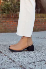 Botines de cuero color beige con detalle de gamuza en el talón y taco bloque de madera.