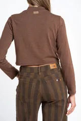 Polera de manga larga color marrón jaspeado, con cuello alto y corte ajustado al cuerpo.