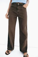 Jeans de tiro medio y corte recto, color marrón chocolate. Presenta un diseño de cinco bolsillos y detalles laterales con tejido de crochet a tono a lo largo de las piernas.