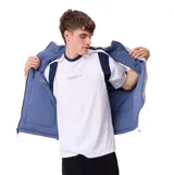 Chaleco acolchado reversible de la marca Rusty, color azul, con cierre frontal completo, cuello alto y bolsillos laterales. Presenta un bolsillo adicional con cierre en el pecho y etiqueta de la marca.