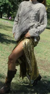 Pollera larga de corte godet, cubierta completamente de lentejuelas verde azulado, con flecos en el ruedo.