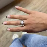 Anillo plateado con una perla blanca central. El engarce simula ramas de árbol.
