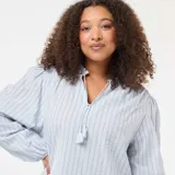 Blusa de corte fluido con estampado de rayas verticales finas en tonos azul y rojo. Presenta cuello redondo con abertura frontal y cordones con borlas, mangas largas abullonadas con puños elásticos y un diseño holgado.