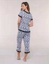 Conjunto pijama de pantalón capri y remera René Rofé, de color blanco con estampado floral en tonos azules y celestes. Remera de manga corta con escote en V y detalles de encaje azul en el escote, las mangas y el ruedo. Pantalón capri con cintura elastizada, cordón de ajuste y encaje en el ruedo.