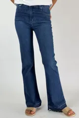 Pantalón de jean azul oscuro, corte oxford, tiro alto y terminación desflecada.