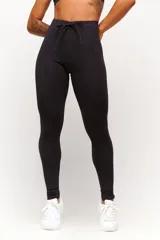 Calza deportiva negra de tiro alto, confeccionada en poliamida con elastano, con costuras laterales visibles y cordón ajustable en la cintura.