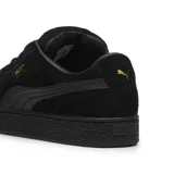 Championes urbanos Puma modelo Suede XL, color negro con detalles en dorado. Confeccionados en gamuza con cordones anchos y suela de goma texturizada.