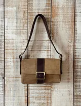 Cartera tipo mini bag de gamuza beige con textura de reptil, solapa frontal con detalle de tira central en cuero marrón oscuro y hebilla metálica. Incluye correa de hombro ajustable en cuero marrón.