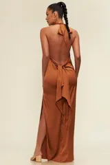 Vestido largo de satén con escote drapeado y espalda descubierta. Presenta un corte fluido y elegante con una abertura lateral en la falda.