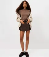 Blusa de manga larga confeccionada en tejido de chenille, con cuello alto y ajuste al cuerpo.