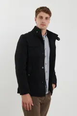 Sobretodo de paño casual color negro, con abotonadura frontal, bolsillos frontales con solapa, cuello alto y detalles de presillas en los hombros.