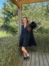 Vestido amplio de lino color verde lima, con cuello mao y abertura frontal con botones de coco. Presenta un diseño con canesú fruncido y volados en los puños de las mangas largas.