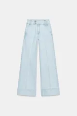 Jeans de tiro bajo con pernera recta y bajo con vuelta. Presenta bolsillos delanteros, bolsillos de plastrón en la parte trasera y cierre frontal con cremallera y botones.