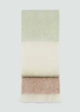 Bufanda de tejido suave con diseño de bloques de color en tonos verde menta, crema y marrón claro, con terminación de flecos en los extremos.
