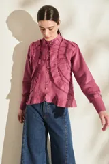 Camisa de lino blanca con cuello mao, manga larga, volados frontales y terminaciones desflecadas, con costuras y botones en tono contrastante.