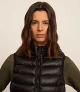 Chaleco puffer deportivo negro, ultraligero, con cuello alto y cierre frontal con cremallera. Incluye bolsita para guardarlo.