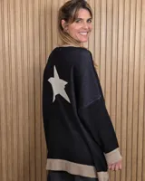Buzo tejido largo de color negro con una gran estrella blanca en la espalda, escote redondo y detalles en color tostado en el cuello, los puños y el dobladillo.