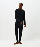 Conjunto de pijama masculino compuesto por una remera de manga larga con cuello redondo y un pantalón largo a juego. Ambas piezas presentan un diseño liso y minimalista, confeccionadas en tejido de modal suave y transpirable.