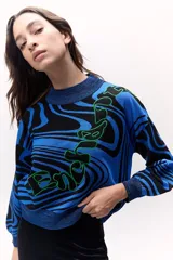 Sweater tejido de punto color azul con diseño marmoleado en negro y aplique bordado con contorno verde.