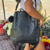 Mochila urbana de eco-cuero marrón tostado, de diseño estructurado con bolsillos laterales y asa superior.