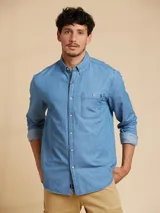 Camisa de manga larga celeste de denim con cuello abotonado, bolsillo en el pecho y logo bordado.