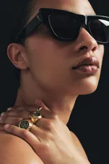 Pack de tres anillos metálicos dorados con aplicaciones de cristales negros. Incluye un anillo fino, un anillo circular con relieve y un anillo tipo sello.