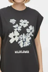 Remera negra de algodón, con cuello redondo, mangas cortas holgadas con vuelta y estampa floral grande en el pecho.