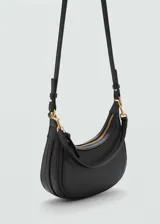 Bolso de hombro tipo hobo en color negro, con diseño curvo y minimalista. Cuenta con cierre de cremallera superior, asa corta ajustable y herrajes metálicos en tono dorado.