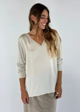 Blusa color beige de mangas largas con cuello en V.