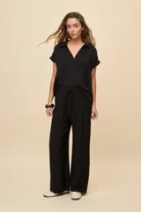 Pantalón gris de corte amplio y silueta fluida, con cintura elástica y cordón ajustable.
