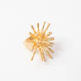 Anillo de diseño orgánico en color dorado, con forma de erizo o estrella de mar con múltiples puntas texturizadas.