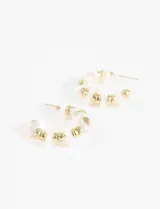 Par de aros tipo argolla con cuentas de perlas blancas y detalles metálicos dorados.