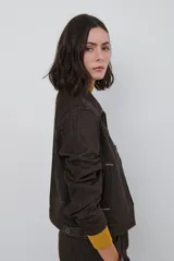 Chaqueta de pana color azul oscuro, con cuello camisero, cierre frontal con botones y bolsillos laterales. Diseño de corte recto y manga larga.