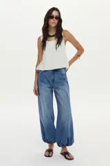 Jean balloon de color azul con lavado vintage, tiro medio, diseño amplio en las piernas y dobladillos inferiores elastizados.