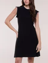Vestido corto azul marino de seda fría elastizada, con escote redondo y sisas decorados con volados fruncidos en contraste de color blanco. Presenta corte entallado en la parte superior y falda acampanada.