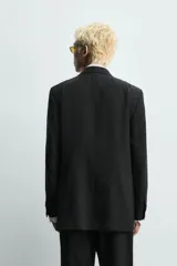 Blazer de corte relajado confeccionado en una mezcla de viscosa y lino. Presenta cuello con solapas de muesca, cierre frontal de tres botones, bolsillo de vivo en el pecho y tres bolsillos con solapa en la cadera. Incluye aberturas en la espalda y medio forro interior.