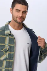Sobrecamisa leñadora de polar a cuadros en tonos verde militar, beige y azul claro. Cuenta con dos bolsillos frontales con solapa, dos bolsillos laterales y cierre con botones a presión. Interior de micropolar.