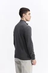 Campera tejida de algodón en color beige, con cierre frontal completo, cuello levemente elevado y puños y ruedo acanalados. Presenta un pequeño logo bordado en el pecho.