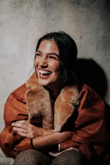 Campera oversize de cuero tostado con solapas y forro interno de corderito sintético azul marino, mangas anchas y detalles de costuras trenzadas.