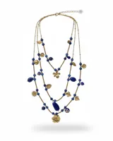Collar largo de tres vueltas elaborado en acero, compuesto por una combinación de piedras naturales azules y dijes metálicos dorados con formas de flores y hojas.