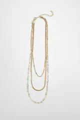 Collar de tres tiras de cadena dorada con diferentes diseños: una cadena fina de eslabones clásicos, una tira plana tipo escama de pescado y una cadena con eslabones en forma de trébol o flor.