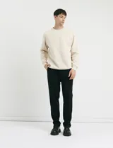 Pantalón jogging de corte recto, confeccionado en tejido circular con cintura elástica y cordón ajustable al tono. Presenta bolsillos laterales tipo parche.